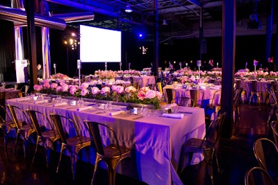 In the dining area defined by black draping, Stark used galvanized metal chairs around a mix of round and long rectangular tables.