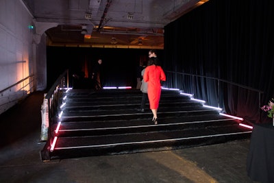 The Tate Americas Foundation's Artists Dinner took place in the raw event space at Skylight at Moynihan Station. Florescent light bulbs led guests through the entrance.