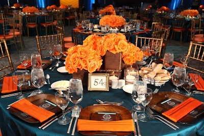 The centerpieces contained lush arrangements of orange roses.