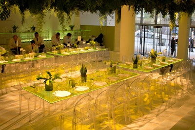 Overhead, dense arrangements of tropical plants were suspended between white pillars, creating a jungle-like canopy effect.