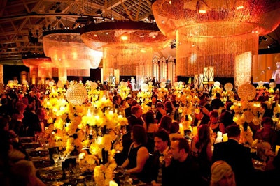 The dining room held five massive crystal chandeliers, which were designed and installed especially for the event. Lighting designer Nol van Genuchten used a golden-hued scheme that reflected the gold-on-black graphics used in the promotional materials for the new film version of The Great Gatsby.