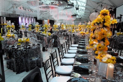 In the dining room, tables were mostly rectangular, but were interspersed with circular tables for six to 10 guests. Linens were black and white, and guests sat in black chairs and ghost chairs. The centerpieces were tall, black and crystal candelabras with daffodils winding up their stems; there were also daffodils clustered into Art Deco-style vases.