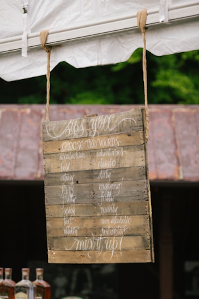 Local distillery Troy & Sons provided an interactive whiskey bar. As noted on a hanging wooden sign created by Dana Cochran of A Fine Line Studio, guests could select two words—such as 'spicy,' 'bold,' and 'fizzy'—to tell the bartender, who then whipped up a drink to match the description.