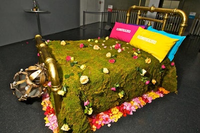 Guests could pose for photos, or just lounge, on brass beds decked with mossy, flowery bedspreads. Plush pillows in bright hues featured the event logo.