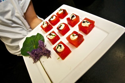 Appetizers circulated on trays decked with leaves and flowers. Menu items included watermelon cubes with fresh feta, tarragon, and balsamic syrup.