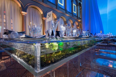 Select Lucite tables served as aquariums with water and plant life inside.