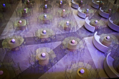 Guests sat for the program at round transparent tables set with clear chairs and centerpieces that mimicked the airport's illuminated pillars.