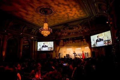 Carrying through the evening's military-camouflage theme, Bentley Meeker projected an abstract camouflage motif on the ceiling of the Plaza's gilded grand ballroom, which was bathed in amber light. Projection screens erected in each corner of the room ensured an unobstructed view for all guests.