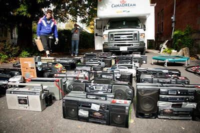 Battery-powered boom boxes, carried by DDP participants, are tuned to the same FM channel so they can simultaneously broadcast the music being delivered via a single FM transmitter that Gary carries in his backpack. While old technology, this system allows perfectly synced music whereas Wi-Fi and Bluetooth cause a delay. The DDP generally brings about 200 boom boxes with them, plus participants often bring their own—even donating them to the cause at the end of the experience. The ideal ratio is one boom box for every five participants, but Gary says it can go as far as 20 to one.