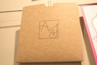 Letter-pressed dots form a swirling vine motif on the invite-holding kraft paper pouch pocket from Designers' Fine Press.
