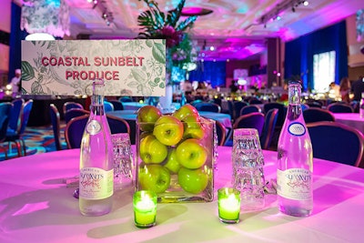 Hargrove kept the pink and green color palette from the event invite evident throughout the event decor, working with Amaryllis to create centerpieces such as tropical flowers and vases of green apples.
