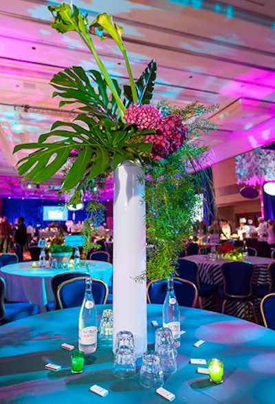 Amaryllis designed the centerpieces of varying heights throughout the room, some including tall palm fronds, while others remained low with dark pink hydrangea or fruit.