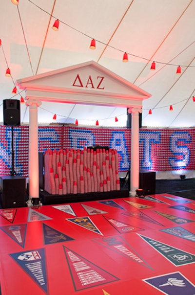 A DJ booth was made of hundreds of stacked Solo cups and framed with columns that evoked a classic fraternity house. Custom graphics of college pennants decorated the dance floor.