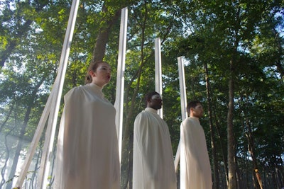For 'Amnesia' by Dilek Acay, six performers—three male, three female—stood like columns on either side of a wooded path, draped in white fabric from the neck down and hurling staccato, gibberish-y words at each other as guests walked in between.