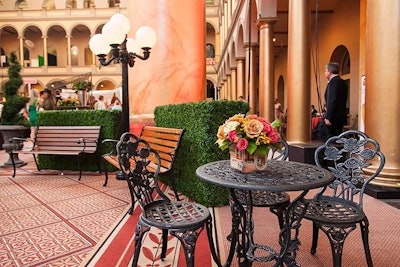 Chicka, Edge Floral Event Designers, and Perfect Setting used park benches, streetlights, black café tables, and shrubbery to create seating vignettes around the middle section of the main atrium.