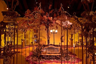 In 2005, Avon created an indoor park to preview its Mark line of cosmetics. A wrought-iron gate opened to four vignettes, which included a small faux maple tree with orange and red foliage and teardrop-shaped glass candleholders suspended from the branches, red umbrellas hovering over a wooden park bench and moss-covered pedestals, and warm yellow lighting.