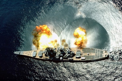 A full broadside photo of the ship firing