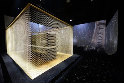 The structure that held the dessert spread at Moët & Chandon's 270th anniversary event was enclosed in a gold-colored cage designed to symbolize a tennis court.
