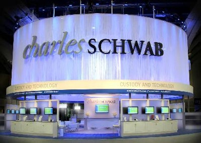 Outer cylindrical presentation of central Charles Schwab press event booth featuring extra-long white curtains and different tones of lighting.