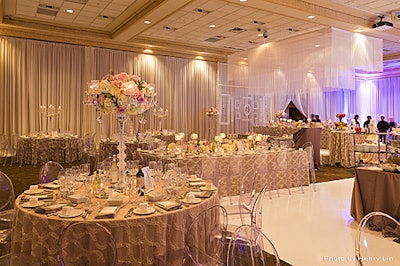 White fringe curtains centered over wedding table at various layered heights.