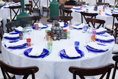 Each table was different and had white tablecloths, wood bistro chairs, and a mixture of Moroccan lanterns and candles. Infusing the dining space with color, JOWY’s design included cobalt blue plates, colored tea glasses for wine, and Moroccan platters and salt and pepper dishes. Guests supped on regionally inspired dishes family style.