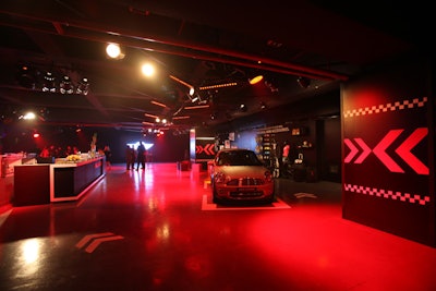 During the opening reception, guests could see the Mini Countryman and its accessories before a video presentation about the car. The roadway design elements carried through the space, with a bar labeled 'Fuel Station' and road markers on the walls.