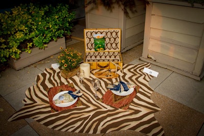 Carrie Leskowitz Interiors made use of textures and patterns with a picnic spread inspired by the mountain town of Aspen, Colorado. Kravet and Ralph Lauren donated the fabrics used for the blanket, place mats, and to line the vintage suitcase.