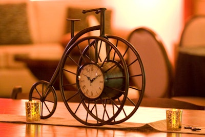 In lieu of floral centerpieces, tables displayed antique-looking vases filled with feathers, clocks in the shape of vintage bicycles, and miniature hot-air balloons.