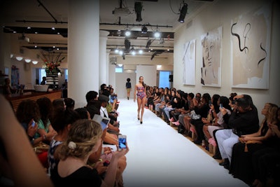 NYFW runway show with artwork in event space.