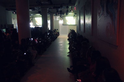 NYFW runway show with multimedia display.