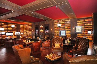 Faux books lined the walls of a library room, where leather seating groups created a clubby, residential feel inside the raw warehouse space.