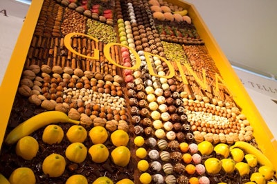 A custom table that continued up a wall featured artfully arranged truffles along with fresh fruit, nuts, and spices, all set in a bed of melted chocolate.