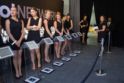 Guests checked in to the event on iPads outside before walking through the black drapes into the event space.