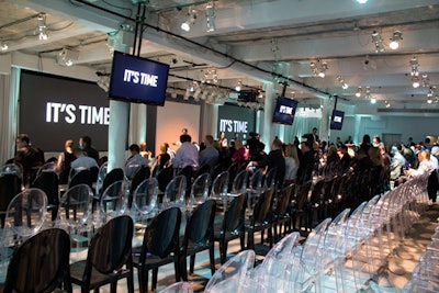 Alternating rows of black and clear chairs provided seating for the programming presentation.