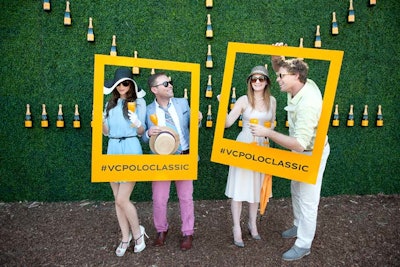 Social media prompts served as props against a grassy wall decorated with Veuve bottles.
