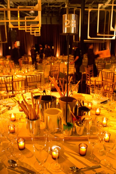 Playful centerpieces featured silver paint cans that held breadsticks and also Sharpie markers that guests could use to draw on the canvas tablecloths.