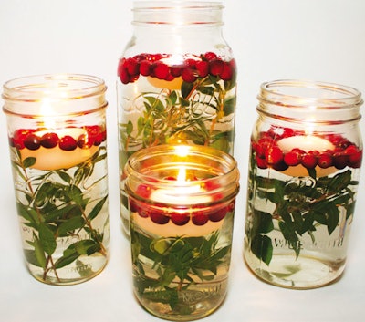An easy D.I.Y. centerpiece: Fill a Mason jar with water, greenery, cranberries, and a ­floating candle.