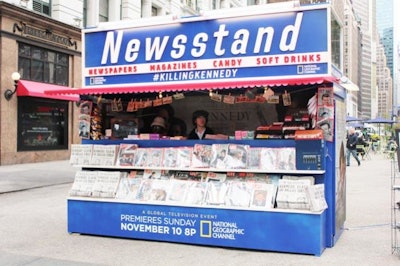 National Geographic Channel brought the headlines of November 23, 1963, to Manhattan by way of a theme newsstand. Posters for the November 10 premiere of its new film, Killing Kennedy, were displayed on the sides and back of the structure, while a hashtag encouraged spectators post photos and comments on social media. The newsstand also had two flat-screen TVs playing the film's trailer and interviews with the cast.