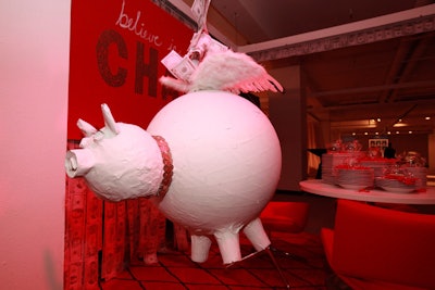 The Diffa Chicago auxiliary board designed the 'Believe in Change' donation table. Plastic piggy banks sat atop stacks of plates in the installation, and guests who donated were given red ribbons to pin on a hanging pig. One of the board members revealed that the pig's round middle was made from a covered yoga ball.