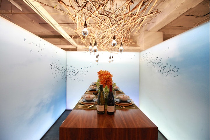 A canopy of twigs and a wraparound scene of birds flying in a blue sky gave a calming vibe to the table from Halcon designed by Perkins & Will and TenFab.