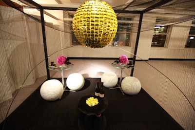 Surrounded by a cocoon of black strings, the Mohawk Group vignette designed by Gensler had a chandelier made of gold-wrapped condoms. A dish of the shiny prophylactics also shone in the monochromatic setting.
