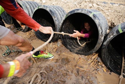 To encourage a sense of teamwork and community, Tough Mudder designs its courses with obstacles that participants can't complete without help from others.