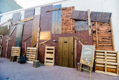 Event planners boarded up the exterior of Long View Gallery with pallets and faux brick to create a speakeasy feel. A sign next to the door read: 'Closed for violation of the National Prohibition Act by the order of the United States District Court.' Event security wore mafia-style fedoras to complete the scene.
