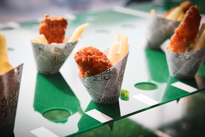 Mary Giuliani Catering & Events offered guests at Jets & Chefs fish and chips in paper cones printed with sports news. Green Lucite trays that resembled a football field displayed the snacks.