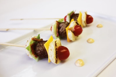 Or, instead of serving potentially sloppy burgers, offer an updated, bite-size take on sliders: Serena Bass for Special Attention Caterers in New York skewers grilled sirloin meatballs with romaine hearts, tomato, cheddar cheese slices, bacon, chipotle mayo, and brioche croutons.