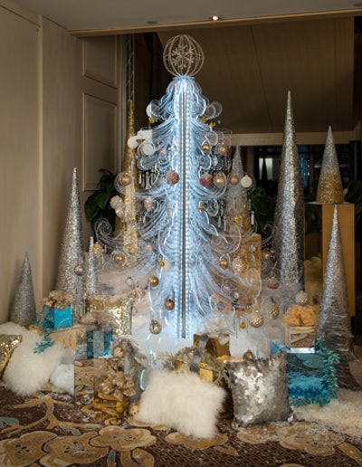 Syzygy Events pieced together panels of engraved routed Lucite to create an unconventional tree. Individual frames carved into the panels served to highlight the gold, white, and bronze ornaments and provide a space for them to move naturally within the rigid panels.
