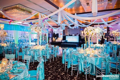 The turquoise table cloths, napkins, sashes, and cushion covers allow the centerpieces to pop