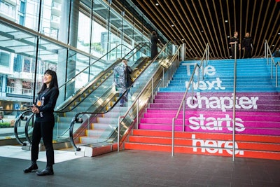 The Vancouver Convention Center's stairs featured color-blocked sections printed with the conference's tagline, 'The next chapter starts here,' which could be viewed from a distance.