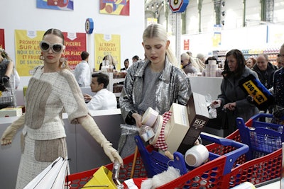 At the end of the show, Karl Lagerfeld's voice came on over a loudspeaker inviting guests to partake in the shopping of goods. While a riot over the collectible product nearly surfaced, security was on hand to remind guests they could not take the product out of the venue. Attendees, however, were able to take some candies and fruit from the stands, not to mention their press kits, which was housed in a Chanel matchbox.