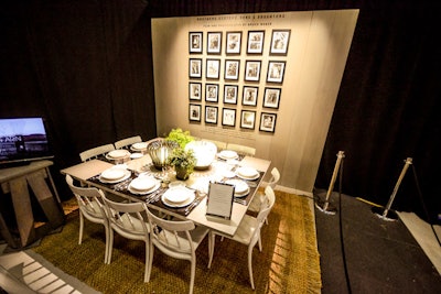 A wall of Bruce Weber portraits from his “Brothers, Sisters, Sons, and Daughters” ad campaign for the retailer served as the backdrop at the Barneys New York table. The minimalist aesthetic was marked by a sleek grey color palette and punctuated by St. Louis Hermès table lamps. A cream colored table with black place mats evoked the retailer’s logo.